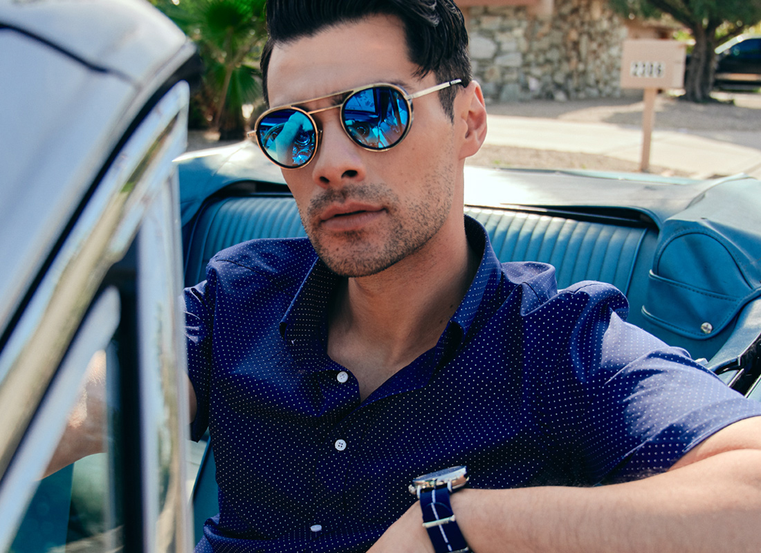 A man behind the wheel of a car modeling an Indochino shirt