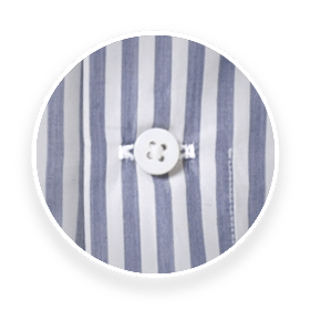 A magnified view of a horizontally placed last button on an INDOCHINO shirt.