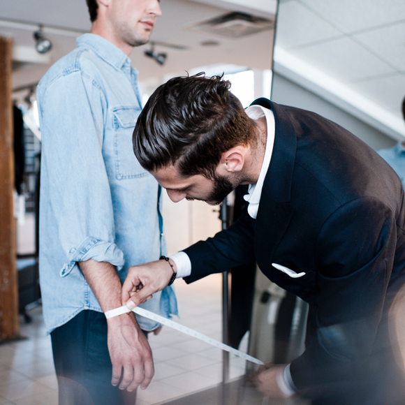 An INDOCHINO style guide measuring a customer.